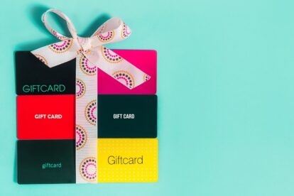 Sechs Geschenkkarten auf türkisfarbenem Hintergrund mit umgebundenem Schmuckband